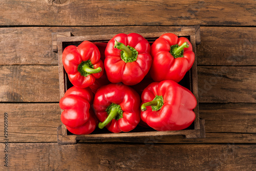 Overhead shot of red bell pepper in box on vintage wooden table with copyspace. Sweet paprika photo
