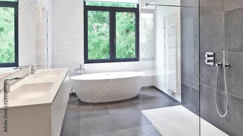 Bathtub in corian, Faucet and shower in tiled bathroom with windows towards garden