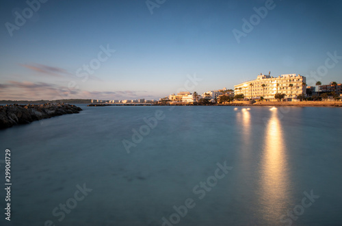 Cala Bona looking towards Cala Millor and the Protur Alicia Hotel at sunrise. Beautiful reflections on the sun in the water which is calm and silky smooth. © Geoff