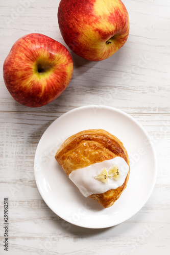 piece of cinnamon apple pie on a white plate with fresh apple in background, autumn food concept