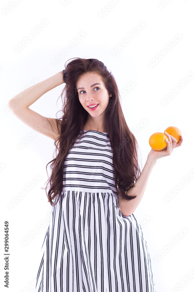 Girl in a striped dress with oranges in her hands. Girl in a striped dress with oranges in her hands.