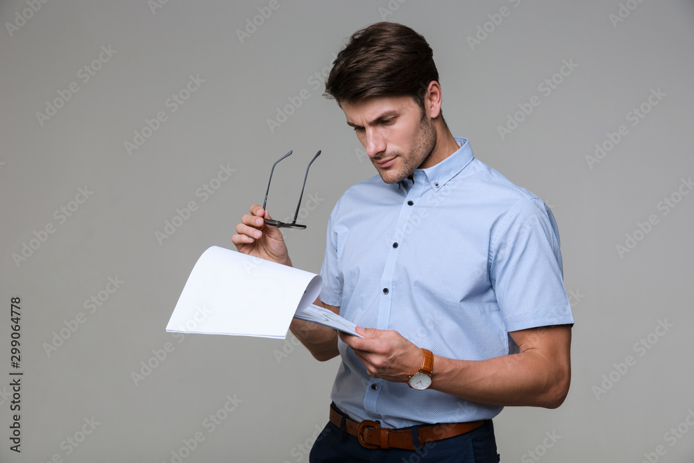 Concentrated business man holding clipboard. Stock Photo | Adobe Stock