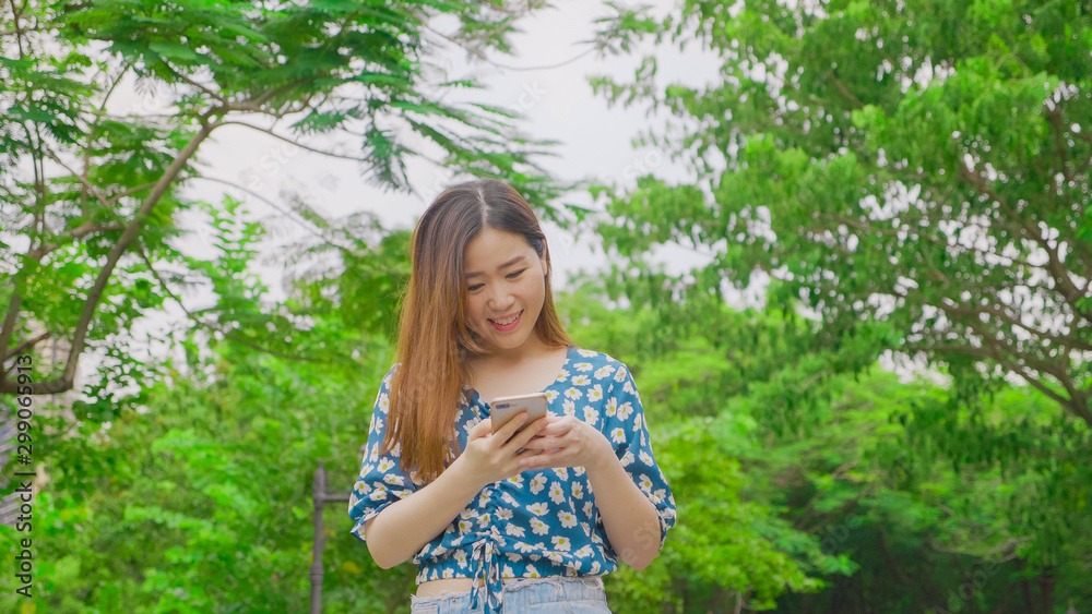 Young pretty woman chatting using phone. Smiling caucasian girl have fun with using smartphone in park Young pretty woman chatting using phone. Smiling caucasian girl have fun with using smartphone in park