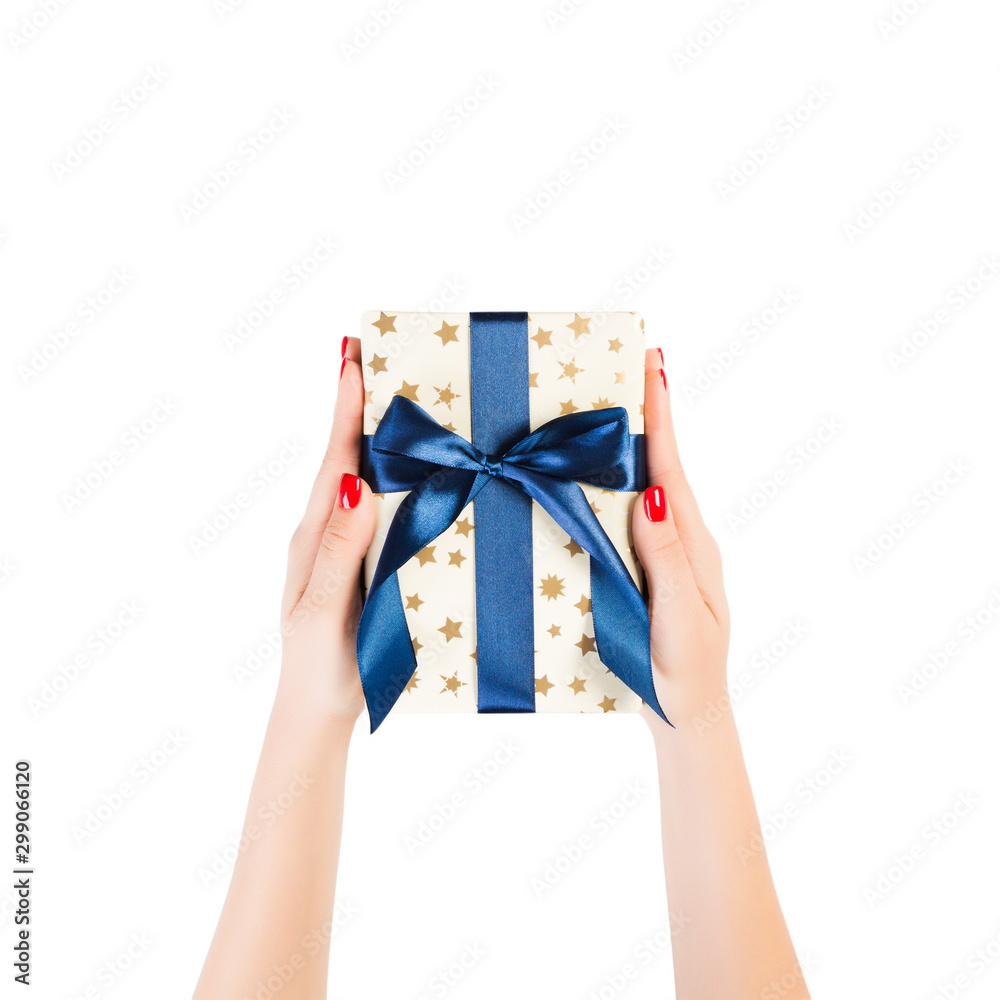 Woman hands give wrapped Christmas or other holiday handmade present in gold paper with blue ribbon. Isolated on white background, top view. thanksgiving Gift box concept Woman hands give wrapped Christmas or other holiday handmade present in gold paper with blue ribbon. Isolated on white background, top view. thanksgiving Gift box concept