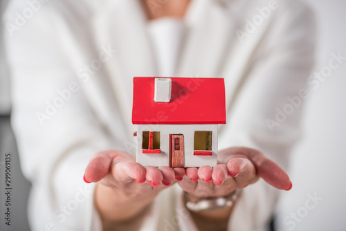partial view of businesswoman showing house model