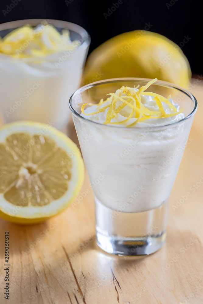 wo glasses with white lemon mousse decorated with zest of lemon. Vertical. wo glasses with white lemon mousse decorated with zest of lemon. Vertical.