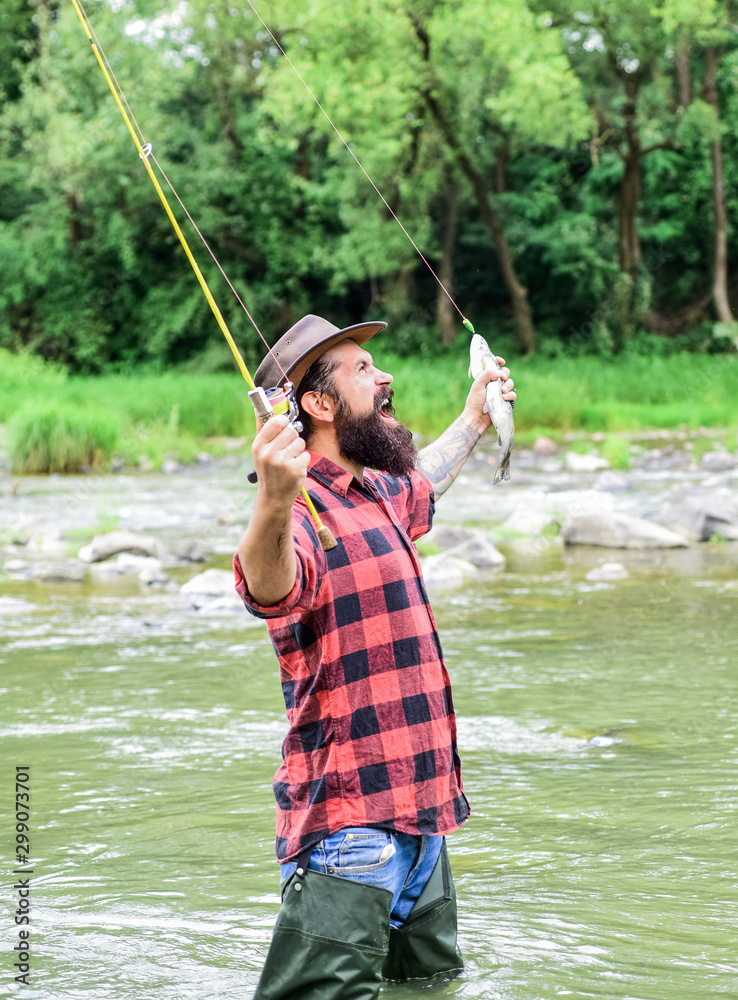 real happiness. mature man fly fishing. man catching fish. summer weekend. Happy  fly fishing. bearded fisher in water. fisherman show fishing technique use  rod. hobby and sport activity Stock Photo