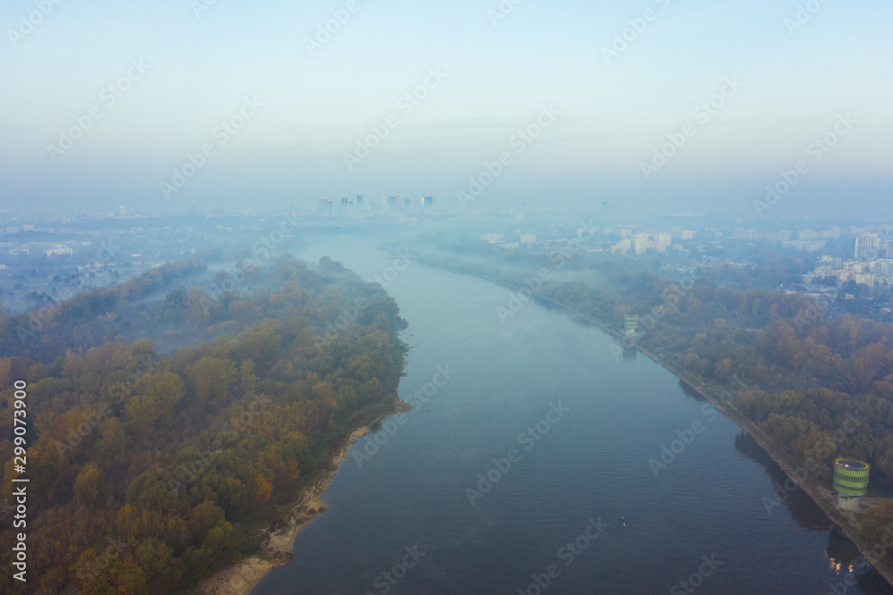 Drone shot on the Vistula river on a foggy morning in Warsaw. Poland. Aerial view of the Vistula River flowing through the city of Warsaw. Drone shot on the Vistula river on a foggy morning in Warsaw. Poland. Aerial view of the Vistula River flowing through the city of Warsaw.