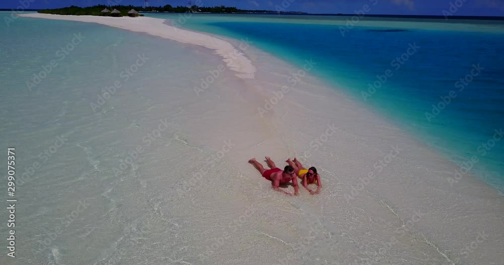 Couple laying on the beach sunbathing Couple laying on the beach sunbathing