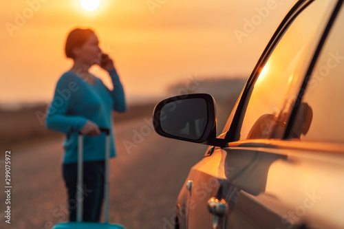 Woman calling roadside assistance after her car broke down