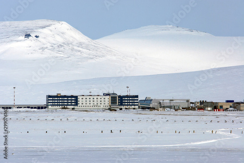 The arctic landscape with the terminal buildings of airport Anadyr (Ugolny Airport). Snow-covered tundra and mountains. Ugolnye Kopi, Chukotka, Siberia, Far East of Russia. photo