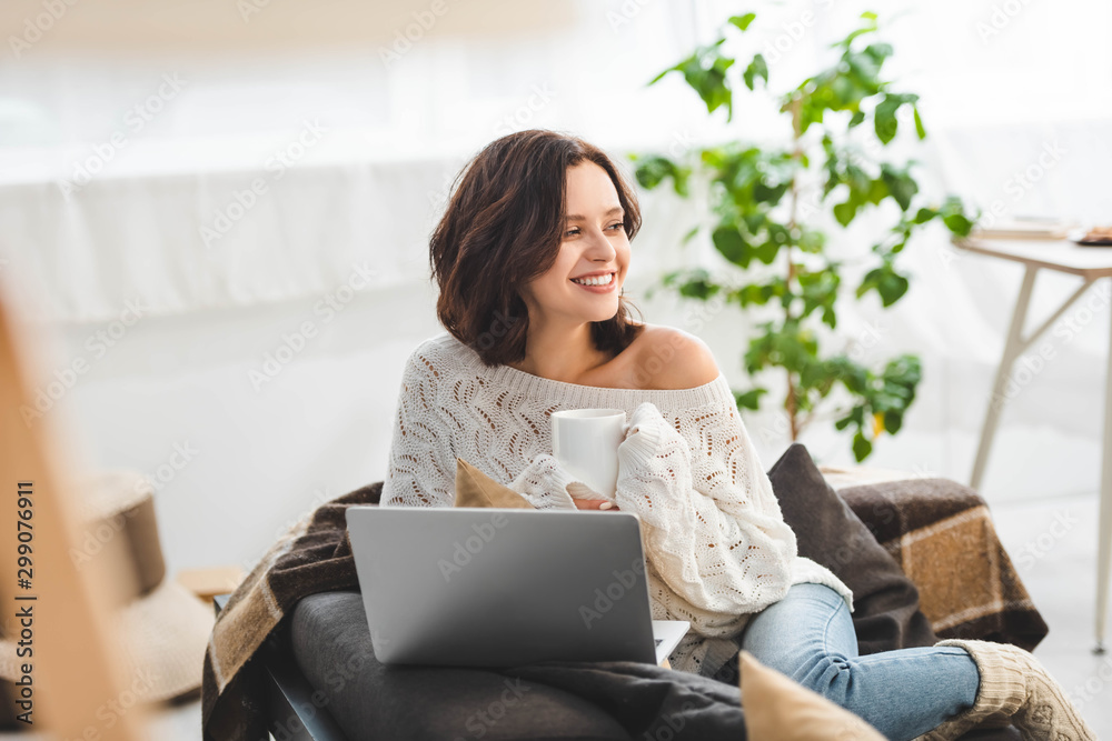 beautiful happy woman with cup of tea using laptop at cozy home beautiful happy woman with cup of tea using laptop at cozy home