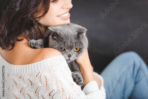 close up of woman with grey scottish fold cat