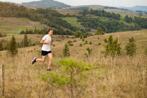 Running fitness man sprinting outdoors with beautiful mountains landscape on background. Caucasian sport male runner training for marathon. © Svetlana