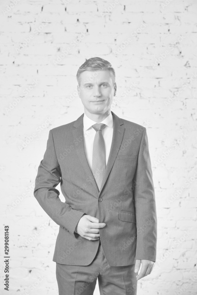 Mature businessman standing against brick wall Mature businessman standing against brick wall