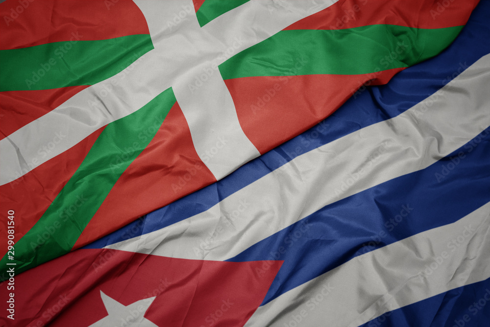 waving colorful flag of cuba and national flag of basque country.