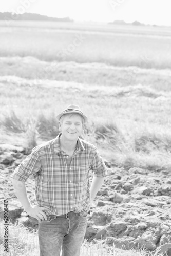 Black and white photo of farmer standing in field