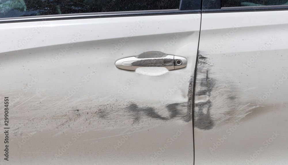 Car door handle and white car door have scratches from damaged by accident