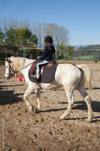 Une jeune cavalière dirige son cheval blanc © Hervé Rouveure