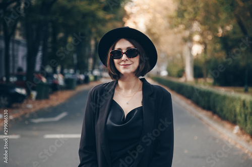 perfect autumn 2019 fashion outfit. european fashion blogger wearing silk satin top, black blazer, square sunglasses and a fedora hat. street style portrait.