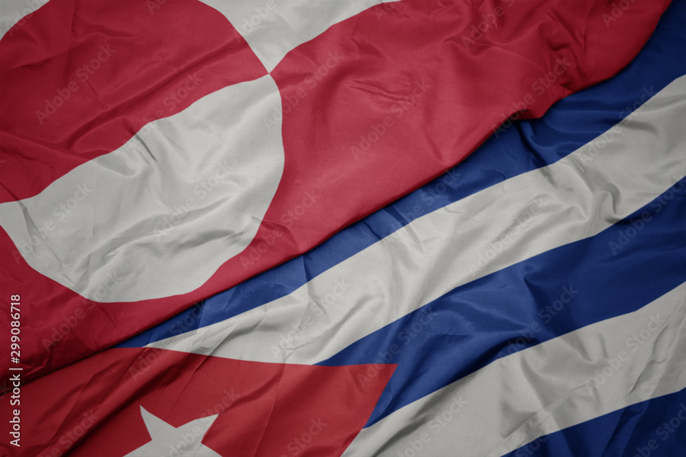 waving colorful flag of cuba and national flag of greenland.