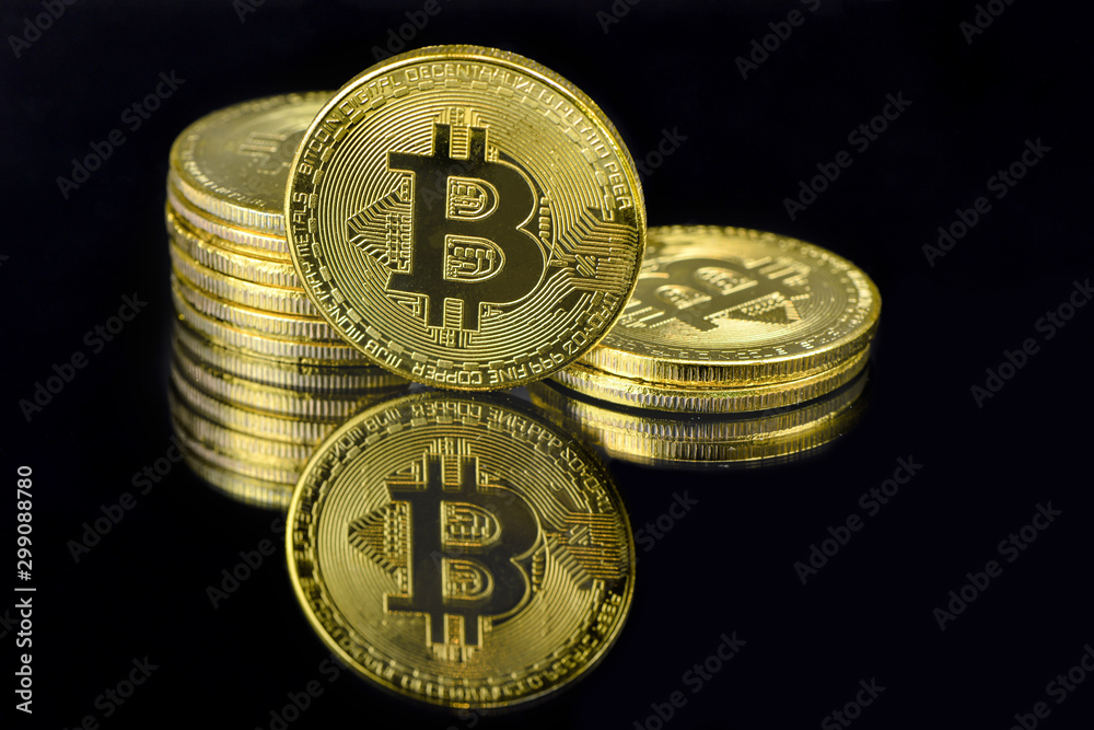 A mirror reflection of a golden BTC coins isolated on black background