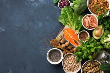Food sources of omega 3 on dark background with copy space top view. Foods high in fatty acids including vegetables, seafood, nut and seeds. Health food fitness
