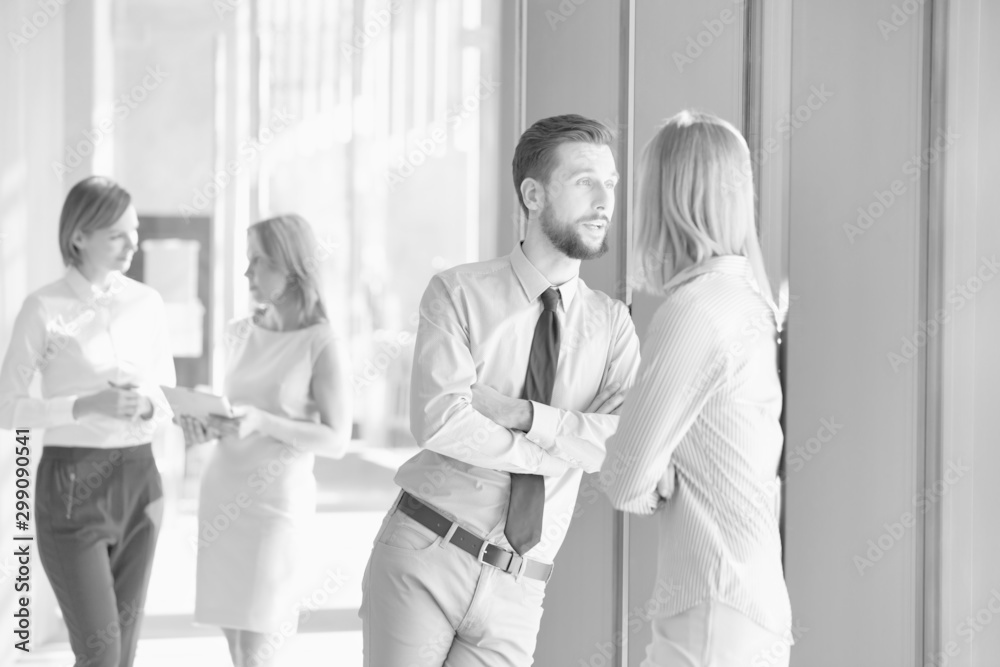 Black and white photo of business people discussing plans before meeting in office hall Black and white photo of business people discussing plans before meeting in office hall