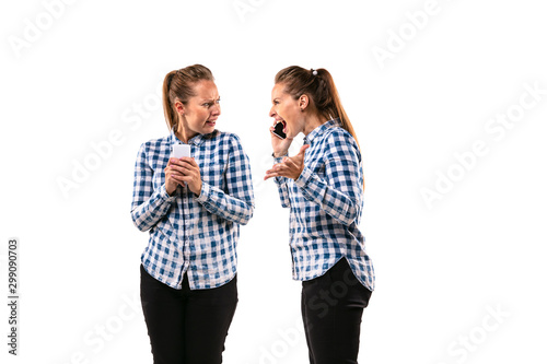 Young handsome woman arguing with herself on white studio background. Concept of human emotions, expression, mental issues, internal conflict, split personality. Half-length portrait. Negative space.