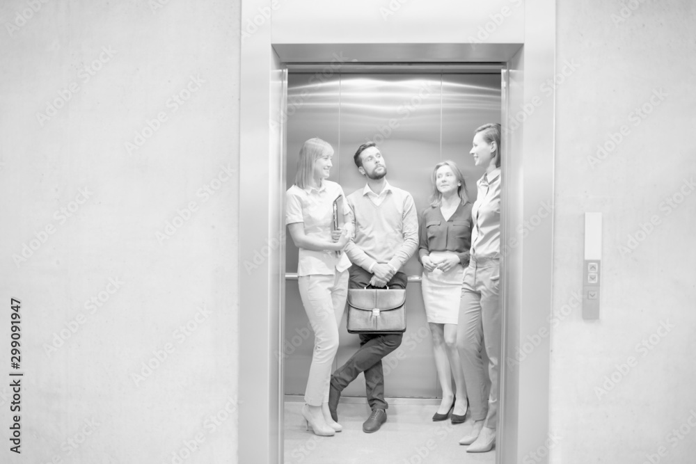 Black and white photo of business people waiting for elevator