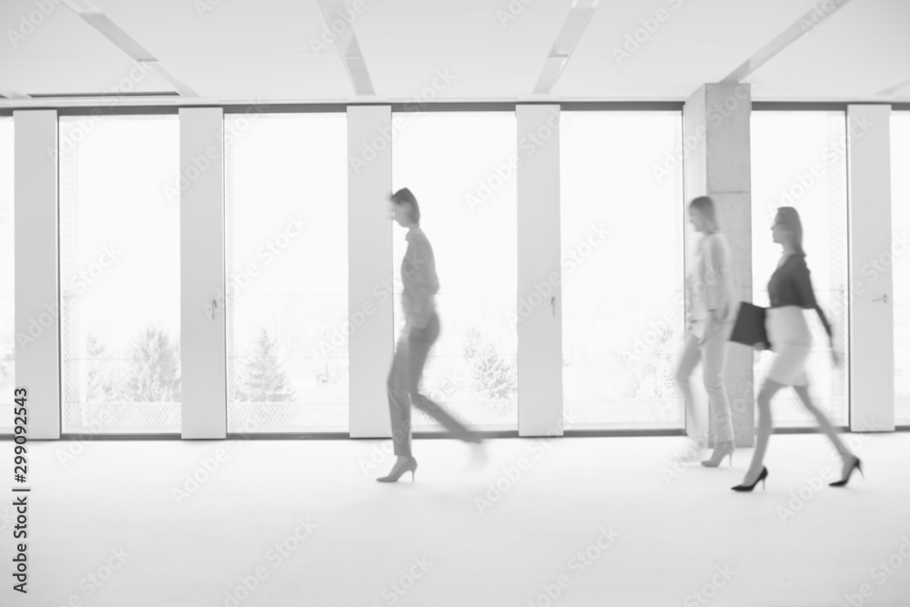 Fototapeta premium Black and white photo of business people walking in office hall