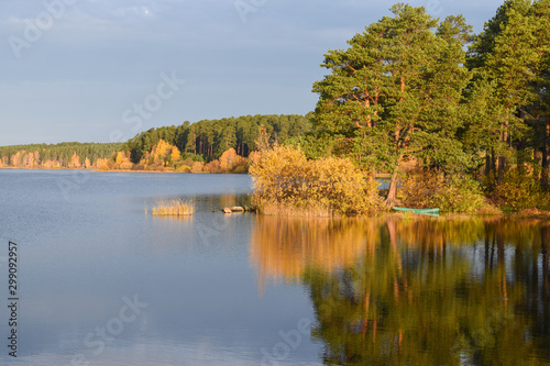 Colorful autumn forest surrounds the mirror surface of the lake.