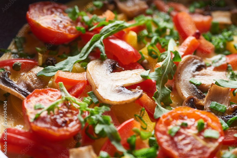 close up of delicious homemade omelet with mushrooms, tomatoes and greens