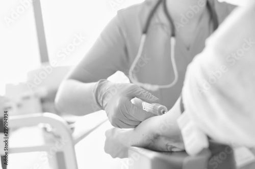 Nurse wearing gloves while injecting patient at hospital