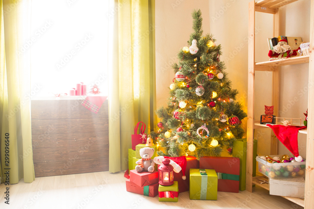 Christmas tree with gifts in a white room. Christmas morning