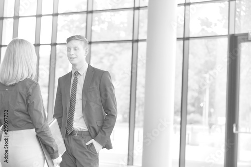 Black and white photo of Young businessman talking with businesswoman in office during meeting