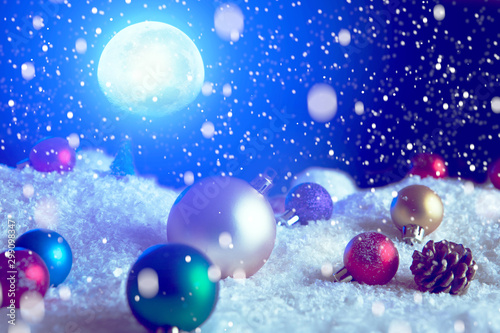 Christmas background with Christmas balls on snow over fir-tree, night sky and moon. Shallow depth of field. The elements of this image furnished by NASA