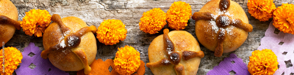 Mexican celebration banner, bread of death. Mexican parties Dead bread and marigold flowers on wooden rustic background. Traditional Mexican Bread of the Dead Pan de Muerto , Top view, Copy space. Mexican celebration banner, bread of death. Mexican parties Dead bread and marigold flowers on wooden rustic background. Traditional Mexican Bread of the Dead Pan de Muerto , Top view, Copy space.