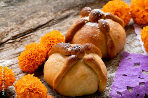 Mexican celebration, bread of death. Mexican parties Dead bread and marigold flowers on wooden rustic background. Traditional Mexican Bread of the Dead Pan de Muerto , Top view, Copy space.