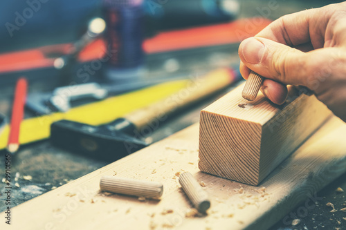 joiner putting dowel pin into a piece of wood photo