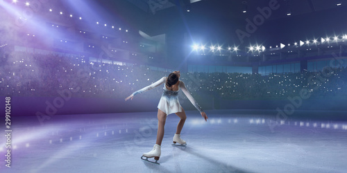 Figure skating girl in ice arena.