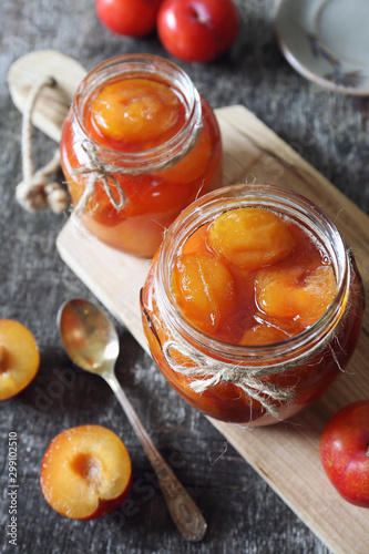 Autumn sweet. Homemade red plums jam in two jars and fruits