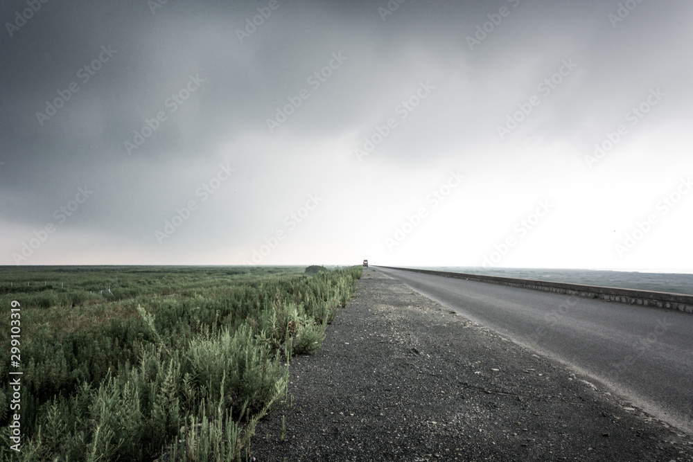 A straight asphalt road under the dark clouds A straight asphalt road under the dark clouds
