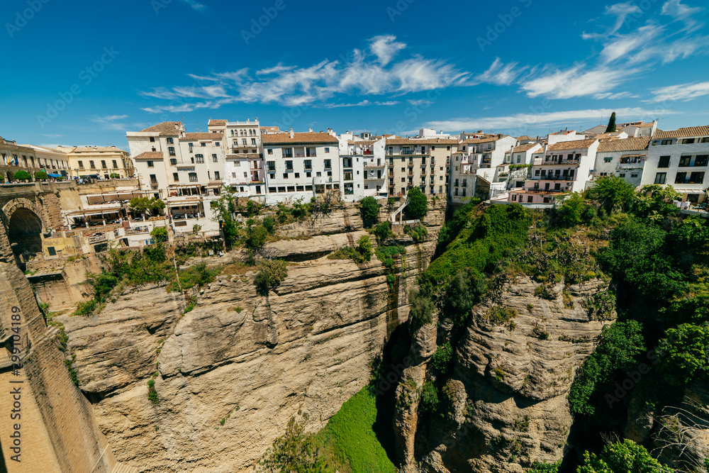 ronda. scenery. magnificent view of the city. foreground an old stone building entwined with greenery