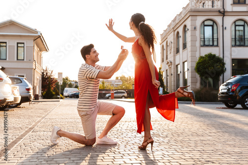 Image of happy handsome man making marriage proposal to his girlfriend