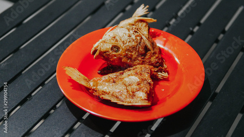 fried carp on a red plate photo
