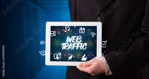 Wallpaper Mural Young business person working on tablet and shows the inscription: WEB TRAFFIC Torontodigital.ca