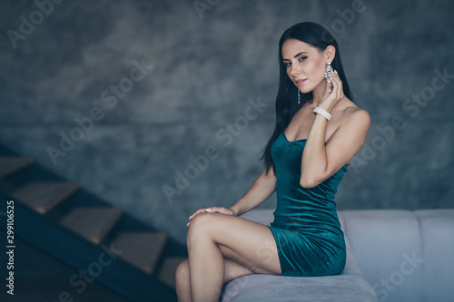 Profile photo of tenderness lady sitting on comfy modern sofa remembering last ideal love night touch earring ear wear formalwear shiny short mini dress apartments indoors