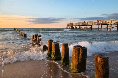 Принти на полотні Wooden pier and breakwater during sunset over the Baltic Sea, Unieście, Poland