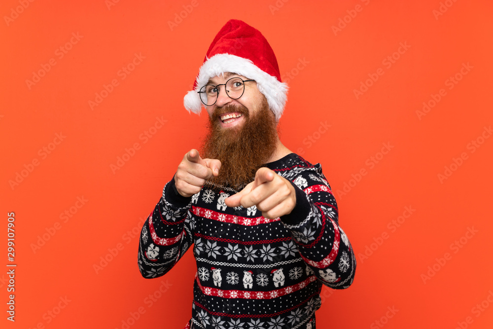 Christmas man with long beard over isolated red background points finger at you with a confident expression - obrazy, fototapety, plakaty 